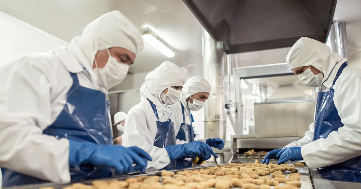 Group of people working at a food factory